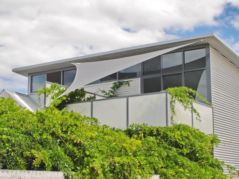 Grey shade sail over a courtyard of a modern home