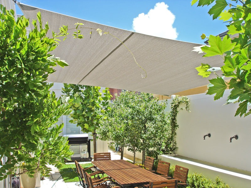 Cream shade sail over an outdoor dining table in a Perth backyard