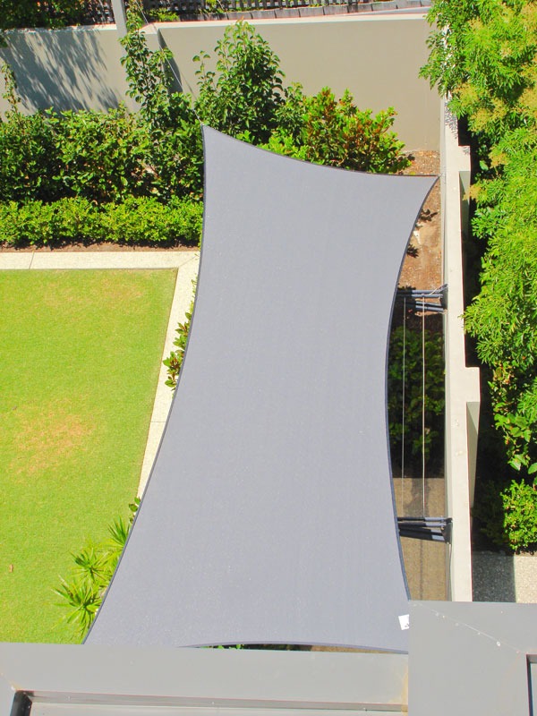 Vertical grey side sail used as a privacy screen in a backyard