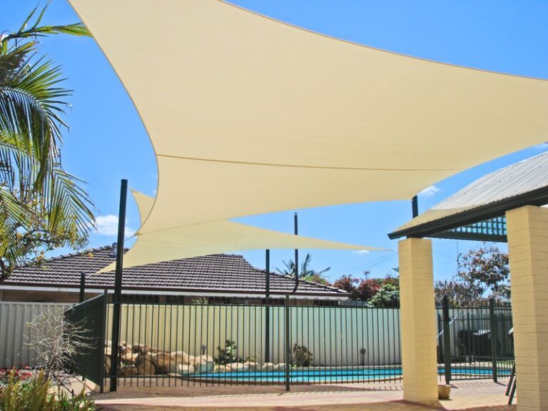 Cream shade sails over a backyard swimming pool