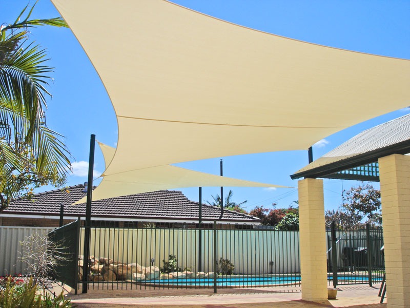 Cream shade sails over a backyard swimming pool