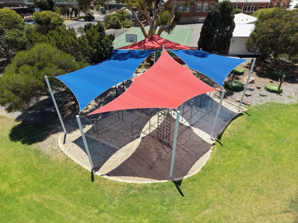 Aerial view of red and blue shade sails over a children’s play area in Perth